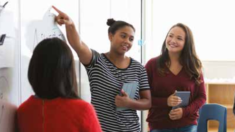 A diverse group of students engaged in learning activities inside a classroom setting.
