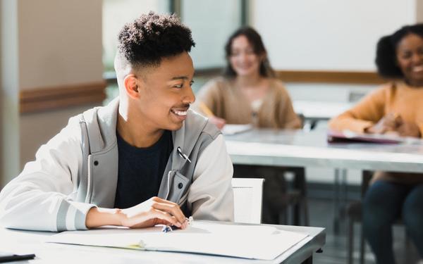 A boy smiling happily in a classroom