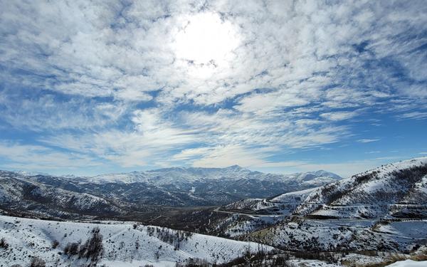 snow covered mountains under blue sky and white clouds during daytime