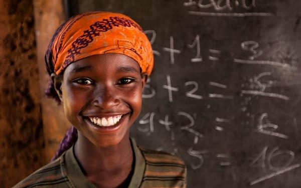 Boy smiling in front of chalkboard
