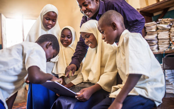 A group of African students are using laptop under their teacher's guidance