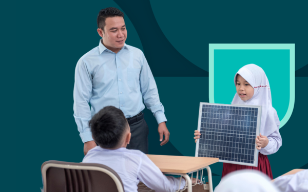 Young female student showing solar panel to young male student alongside teacher