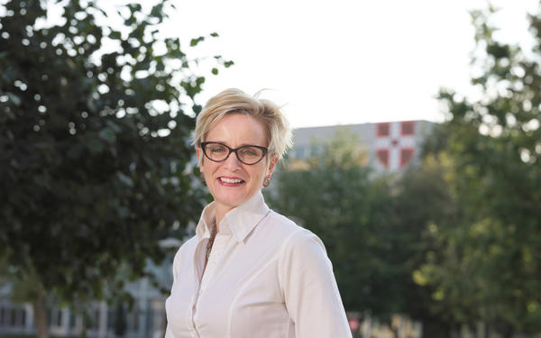 Mandy Hill, Cambridge's Managing Director of Academic Publishing, standing in front of University Printing House.