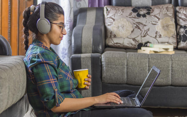 Student working with a laptop with headphones on