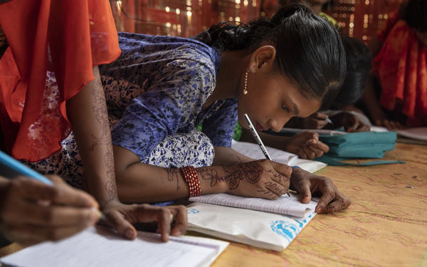 Girls learning and writing in a refugee camp