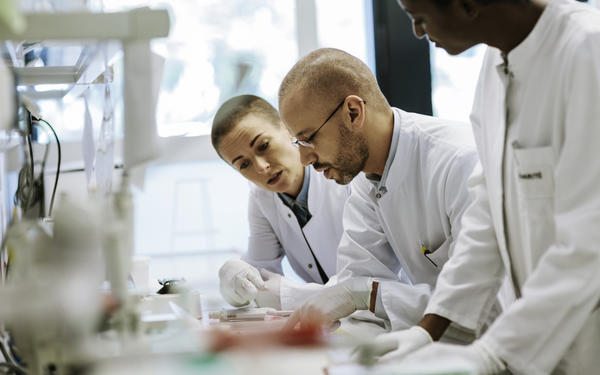 Photo of three scientists working together in a laboratory
