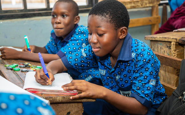 Two boys writing in class