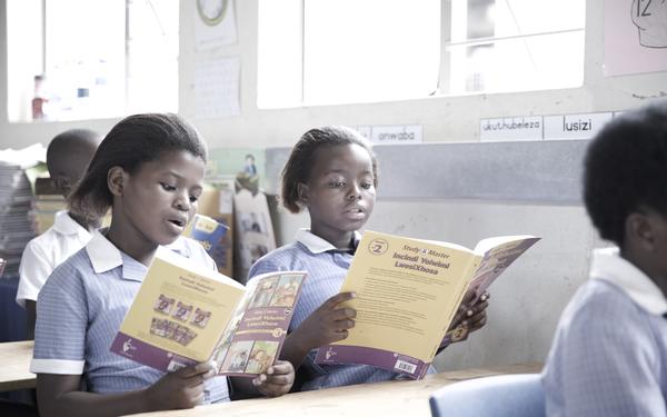 Two girls reading Cambridge book