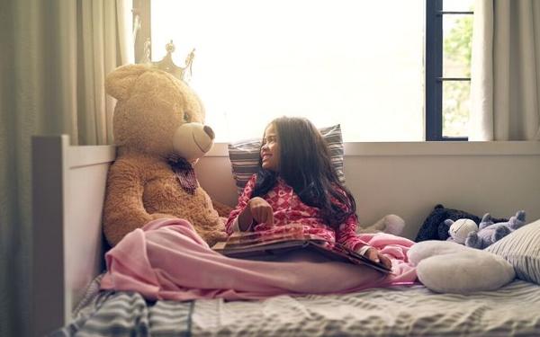 Student reading to teddy