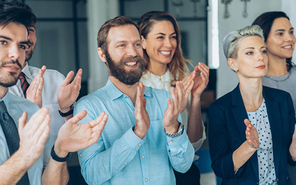 seven colleagues standing up and applauding
