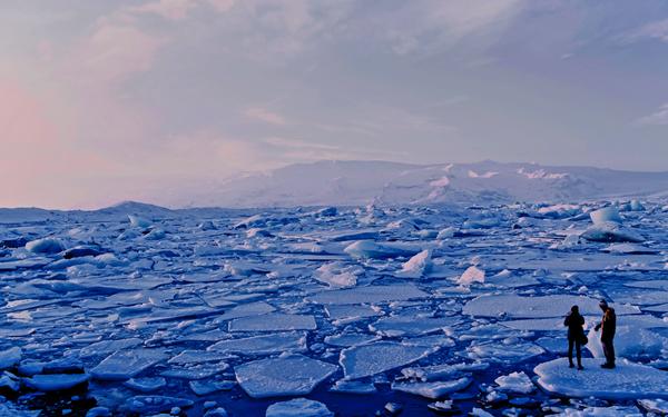 two people standing on ice in polar region