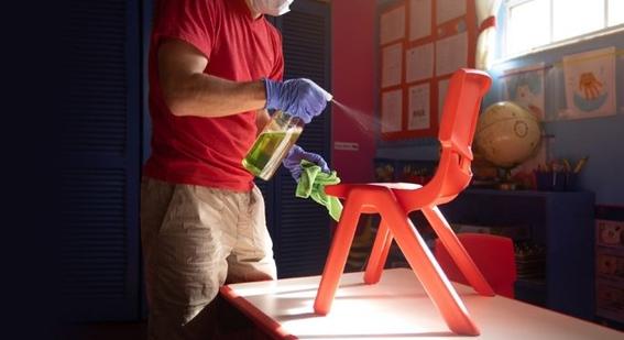 Man in mask cleaning chair 
