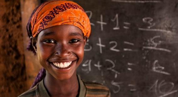 Boy smiling in front of chalkboard