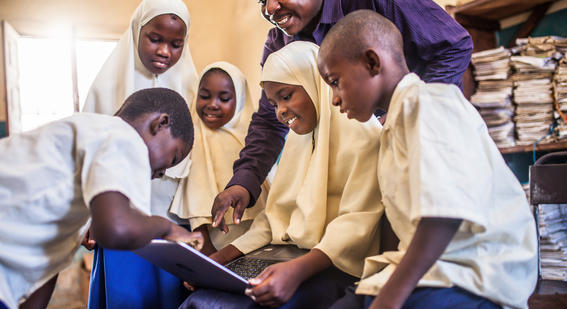 A group of African students are using laptop under their teacher's guidance