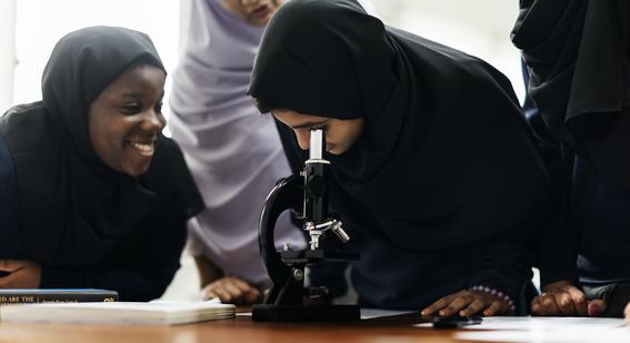 Students around microscope