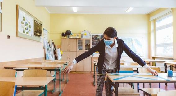 Teacher measuring distance between desks