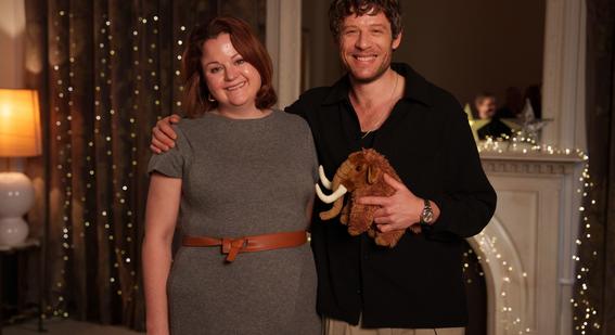 author Dr Rose Stewart smiles and poses for photo with actor James Norton, who is holding a stuffed mammoth toy