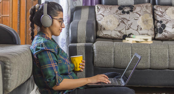Student working with a laptop with headphones on