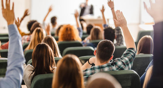 Students in classroom raising their hands