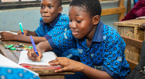 Two boys writing in class