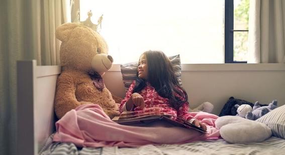 Student reading to teddy
