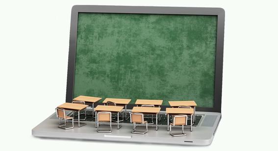 Laptop with exam hall desks and chairs over the keyboard 