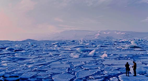 two people standing on ice in polar region