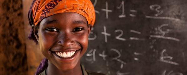 Boy smiling in front of chalkboard